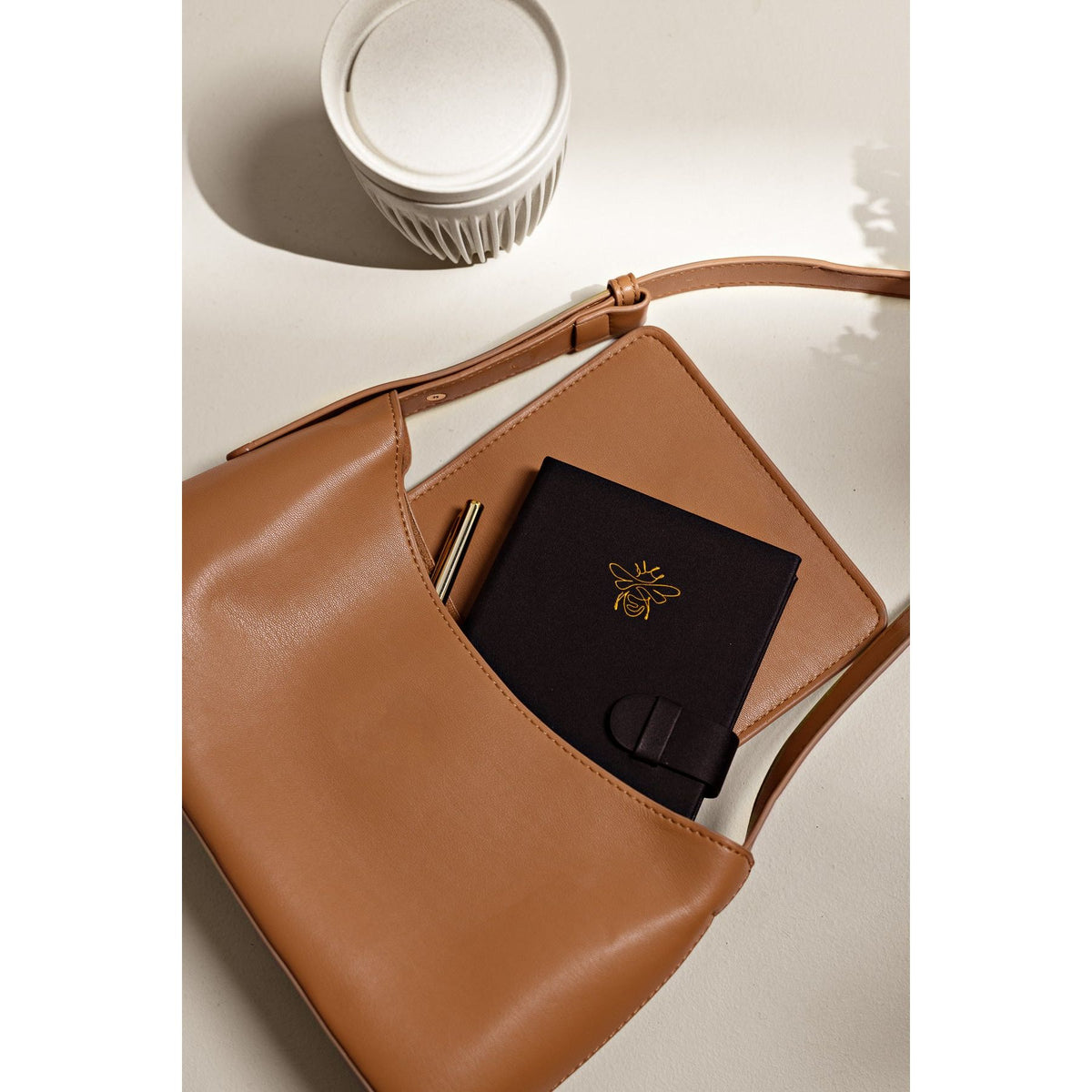 Corner detail of the 2027 Pocket Diary | Gold Bee cover on a flat lay background